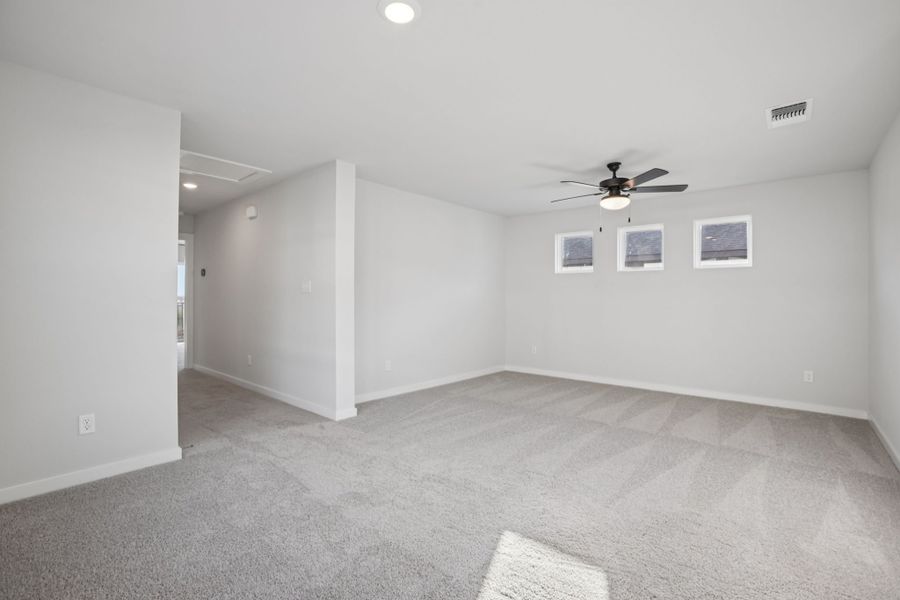 A room with a ceiling fan and a door.