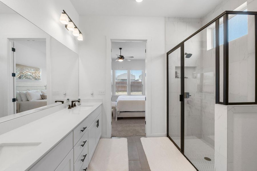 Full bath with double vanity, a ceiling fan, a marble finish shower, and ensuite bathroom