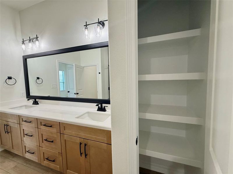Full bath featuring double vanity and tile patterned floors