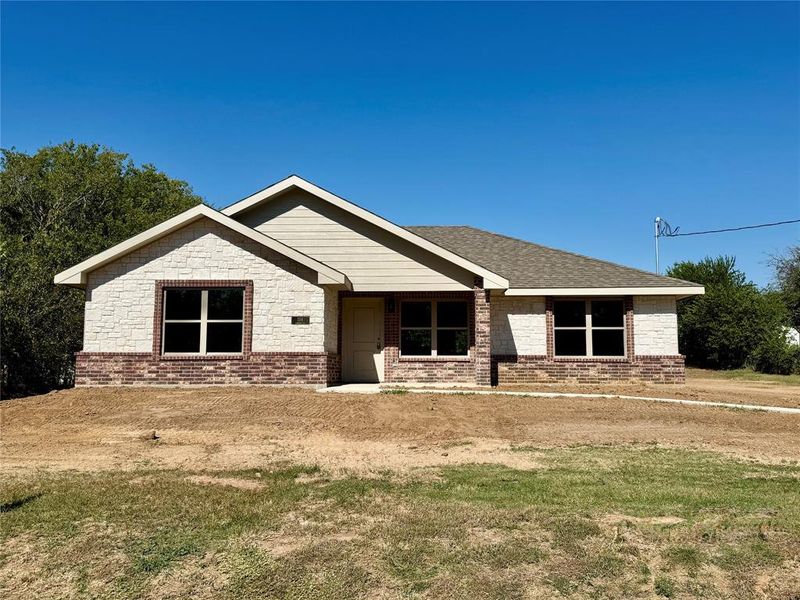 Ranch-style house with a front lawn, a porch, brick siding, and a shingled roof
