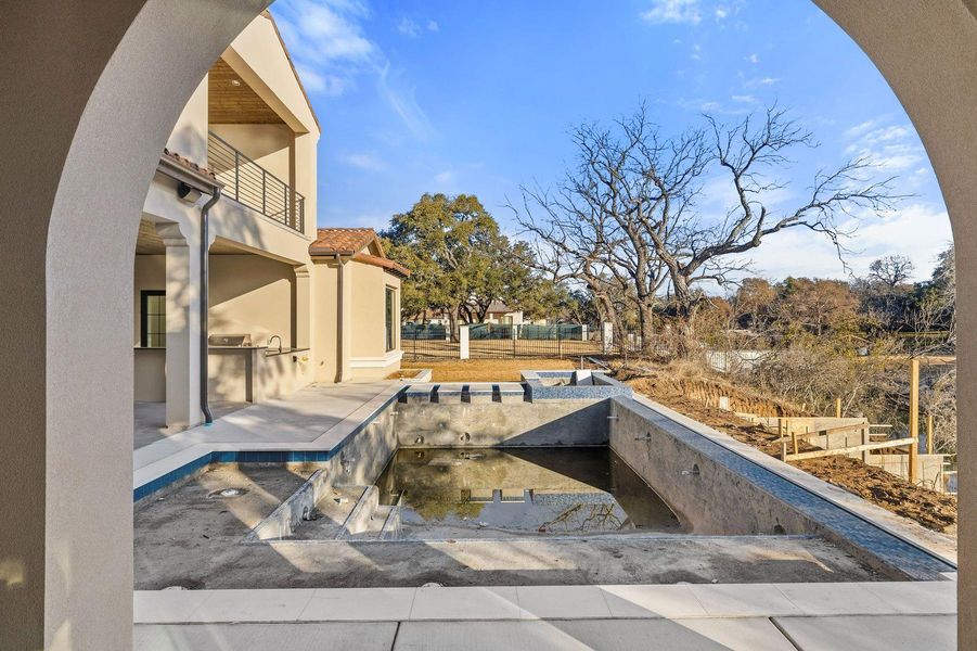 View of swimming pool with area for grilling, a balcony, and patio surround