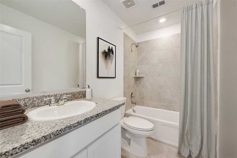 Full bathroom with tile patterned flooring, vanity, toilet, and shower / tub combo