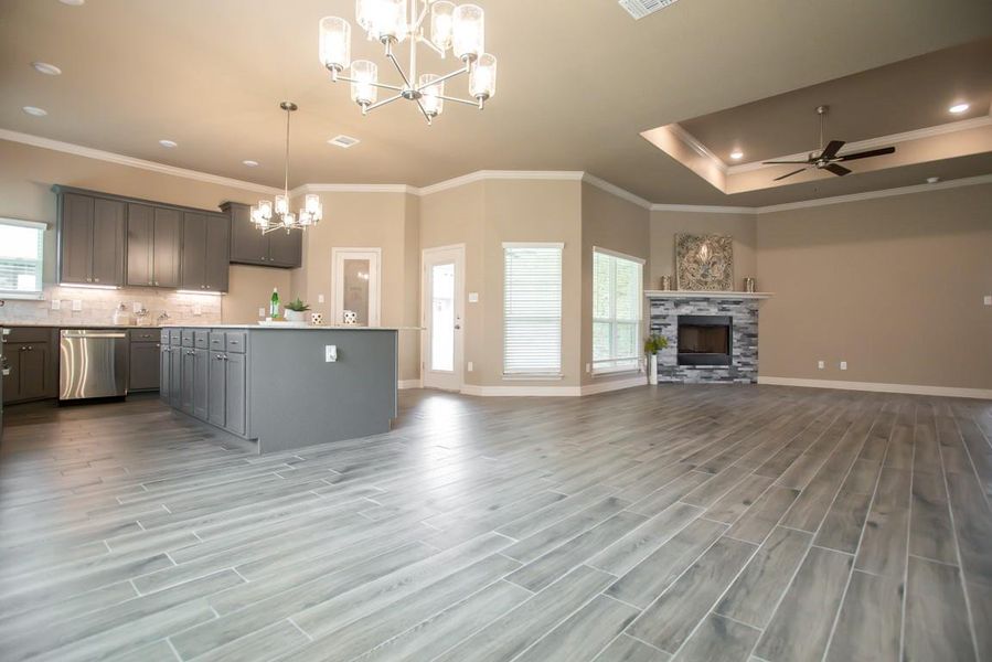 Kitchen featuring a chandelier, crown molding, wood finished floors, open floor plan, and gray cabinets Kitchen featuring a chandelier, crown molding, wood finished floors, open floor plan, and gray cabinets