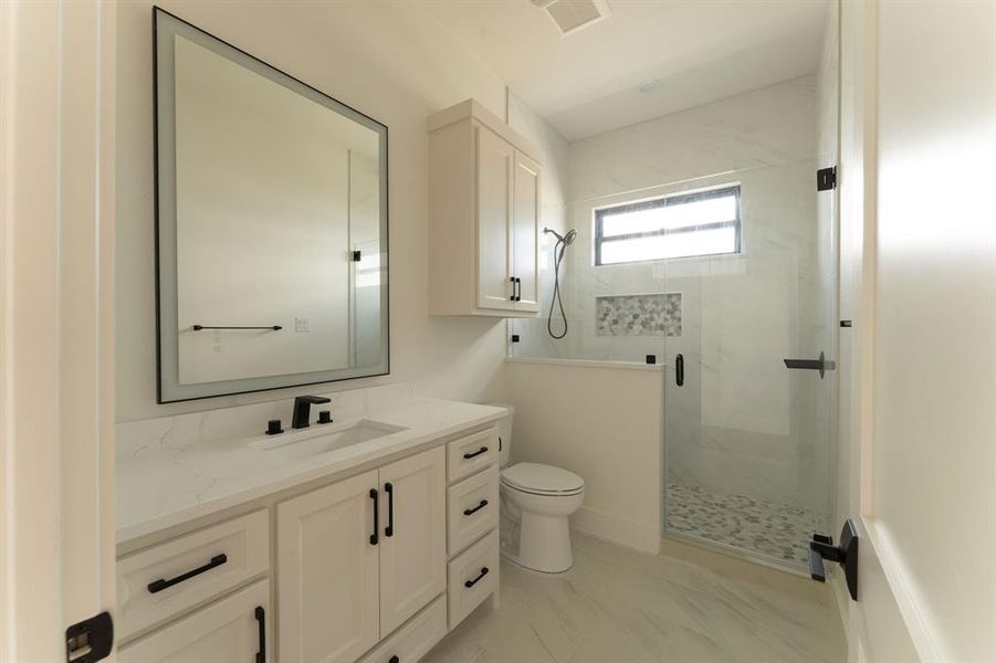 Full bathroom featuring vanity and a marble finish shower