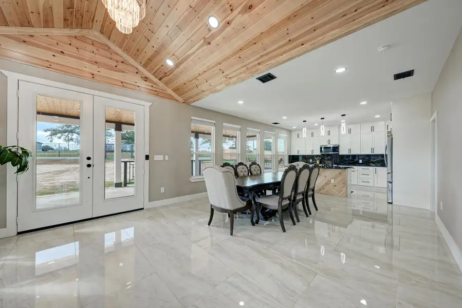 Gleaming tile floors and natural wood ceilings elevate this open dining and kitchen area. Gleaming tile floors and natural wood ceilings elevate this open dining and kitchen area.