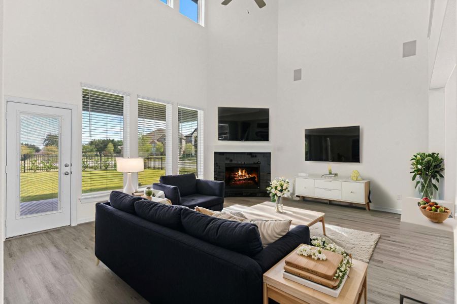 Photo is Virtually Staged — Stunning two-story family room with a wall of windows, stylish fireplace, and plenty of natural light — ideal for gatherings or relaxing evenings. Photo is Virtually Staged — Stunning two-story family room with a wall of windows, stylish fireplace, and plenty of natural light — ideal for gatherings or relaxing evenings.