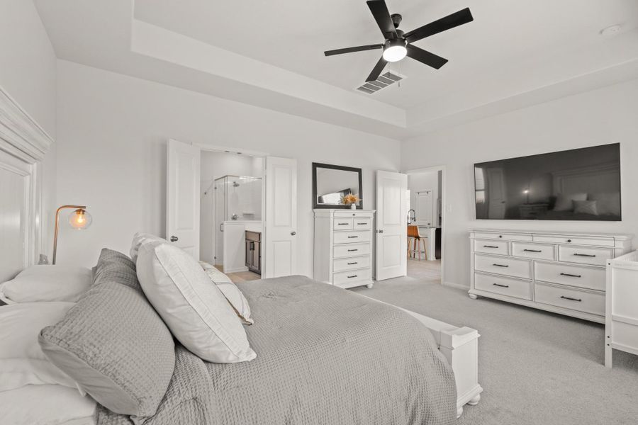 What a wonderful place to come home to! This stunning primary suite greets you with high ceilings, a modern ceiling fan, and an ensuite bathroom.