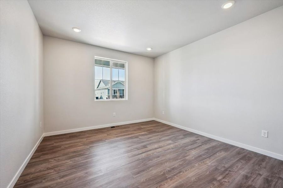 A room with a wood floor and a window.