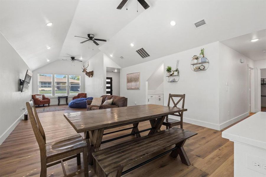 Dining area with dark wood-type flooring, recessed lighting, and high vaulted ceiling