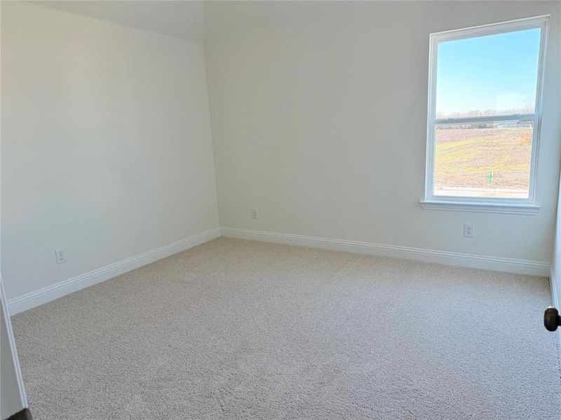 Spare room with carpet and baseboards