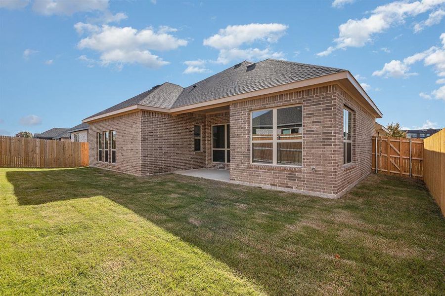 Rear view of house featuring a yard and a patio