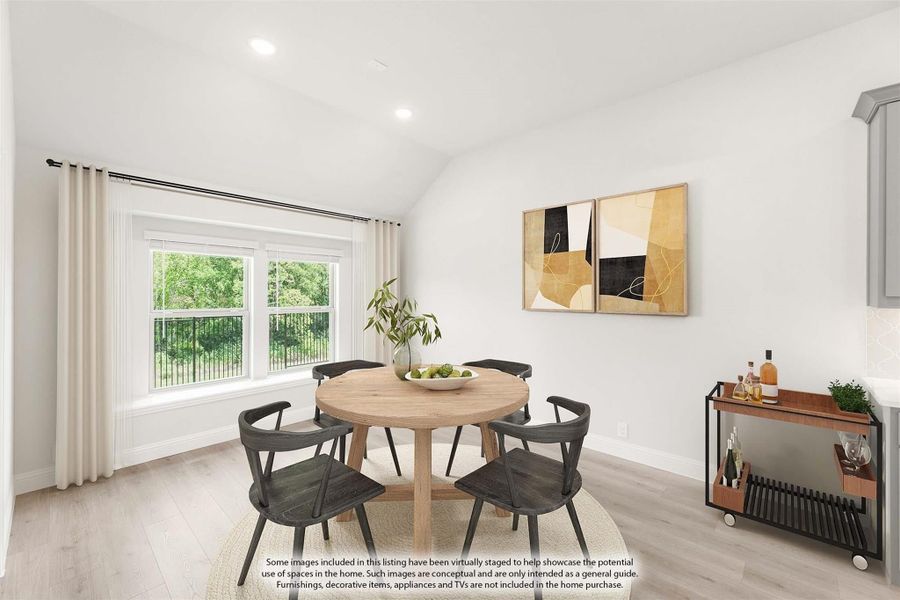 Dining room with round wood table, four dark chairs, vaulted ceiling, and large window with garden view Dining room with round wood table, four dark chairs, vaulted ceiling, and large window with garden view