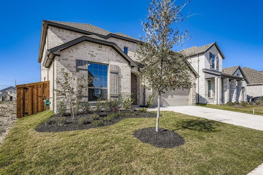 French country inspired facade with brick siding, concrete driveway, and an attached garage French country inspired facade with brick siding, concrete driveway, and an attached garage