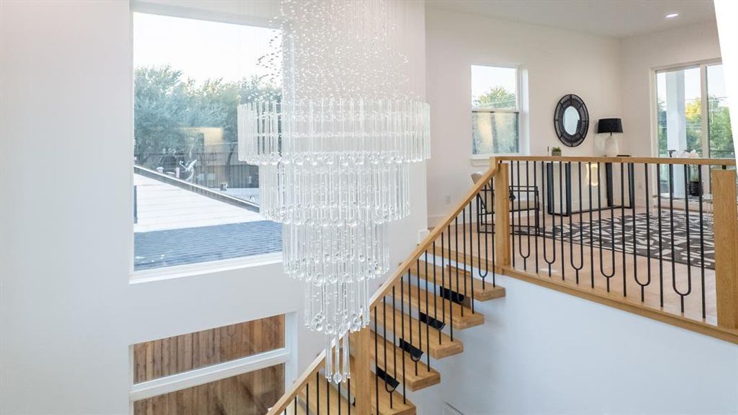 Stairway featuring a chandelier and wood finished floors