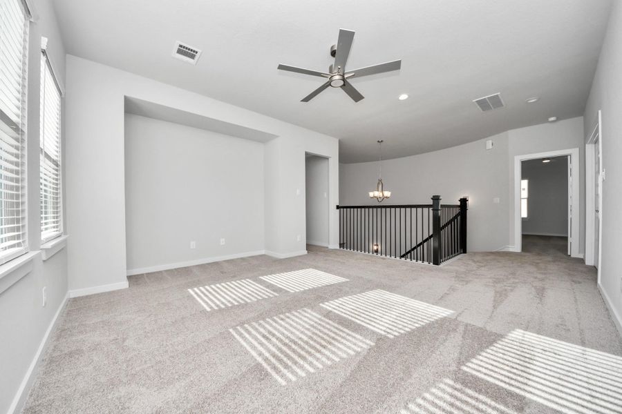 Ascend to relaxation in this fantastic game room! Ideal for both casual gatherings and adult gaming, it boasts plush carpet, lofty ceilings, custom paint, and ample windows for abundant natural light.