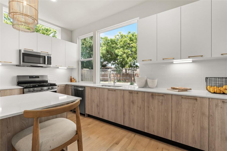 Bright & functional kitchen highlighted by under-cabinet lighting and a large picture window above the sink that floods the kitchen with natural light.