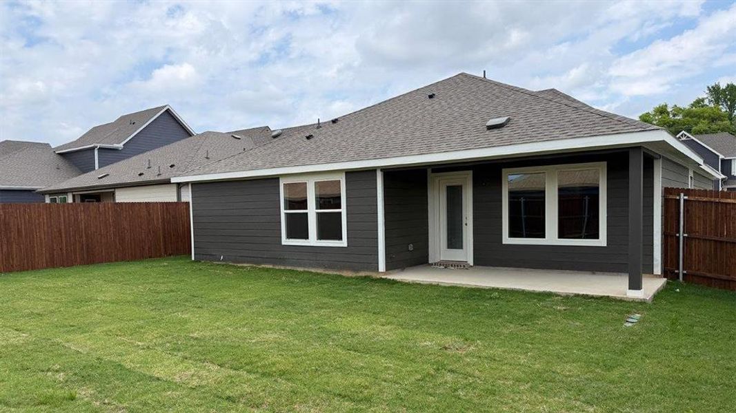 Expansive backyard featuring a manicured lawn, wood privacy fencing, and a concrete patio Expansive backyard featuring a manicured lawn, wood privacy fencing, and a concrete patio