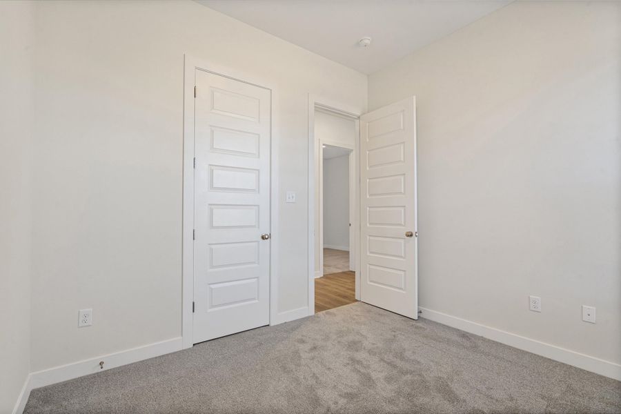 Empty room featuring baseboards and light colored carpet