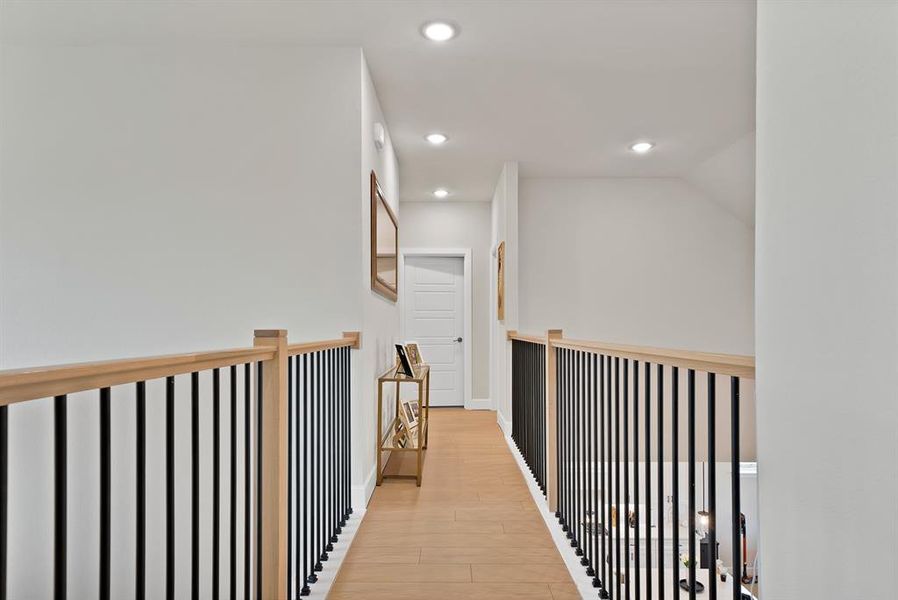 Upper-level hallway featuring wood-finish flooring, recessed lighting, and white walls Upper-level hallway featuring wood-finish flooring, recessed lighting, and white walls