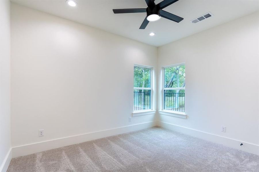 Carpeted empty room with ceiling fan