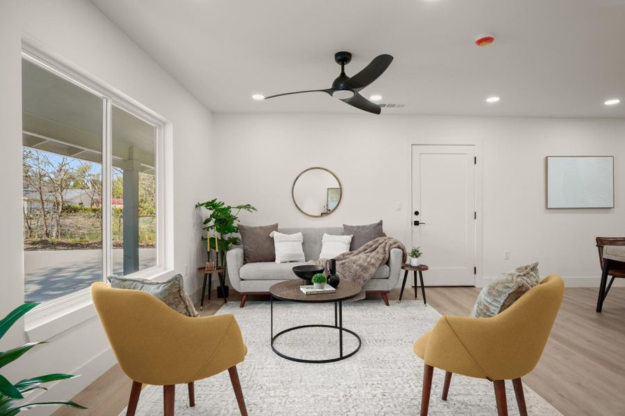 Living area featuring light wood-type flooring, a ceiling fan, and recessed lighting