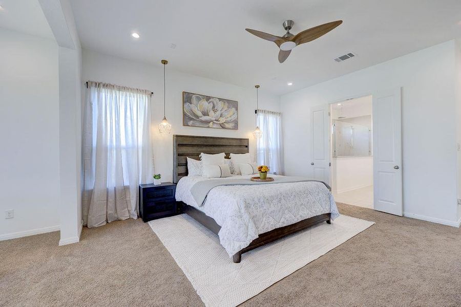Primary Bedroom with light carpet, multiple windows, ceiling fan, ensuite bath, and recessed lighting