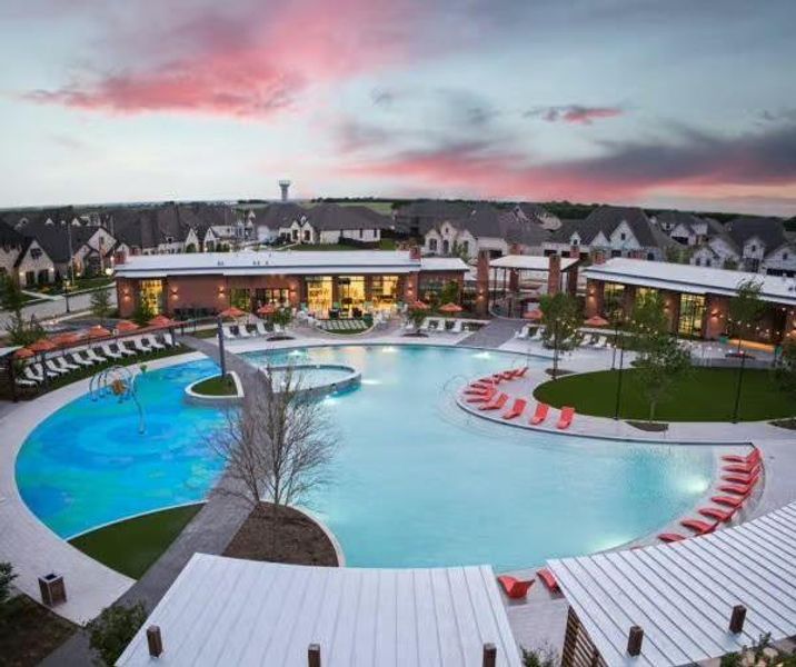Pool at dusk featuring a community pool and a patio