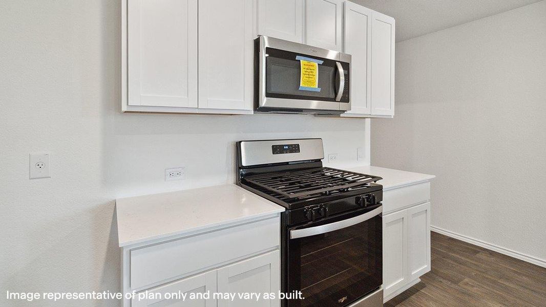 A well-appointed kitchen showcasing a sleek stainless steel microwave and gas range. A well-appointed kitchen showcasing a sleek stainless steel microwave and gas range.