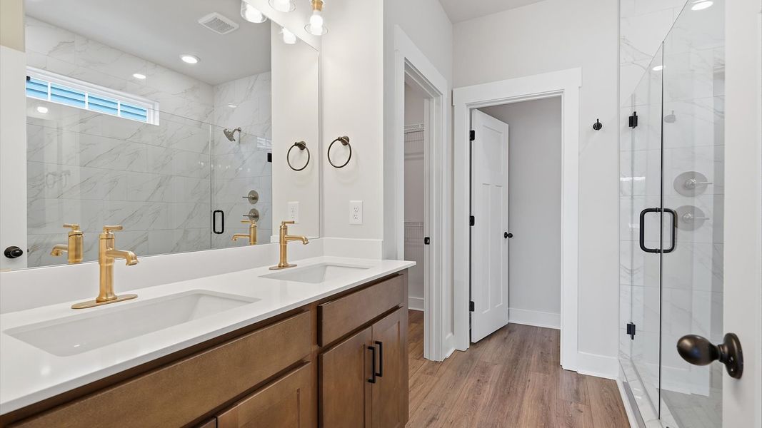 Exceptional en-suite with dual vanity and glass-enclosed walk-in shower for superior everyday comfort by DRB Homes Exceptional en-suite with dual vanity and glass-enclosed walk-in shower for superior everyday comfort by DRB Homes