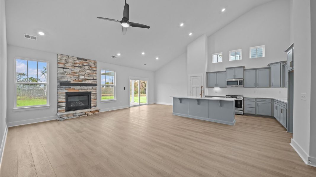 First-class living space featuring expansive ceilings, elegant design, and open sightlines to the kitchen First-class living space featuring expansive ceilings, elegant design, and open sightlines to the kitchen