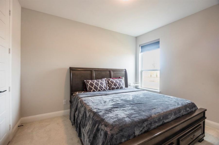 Bedroom featuring light colored carpet and baseboards