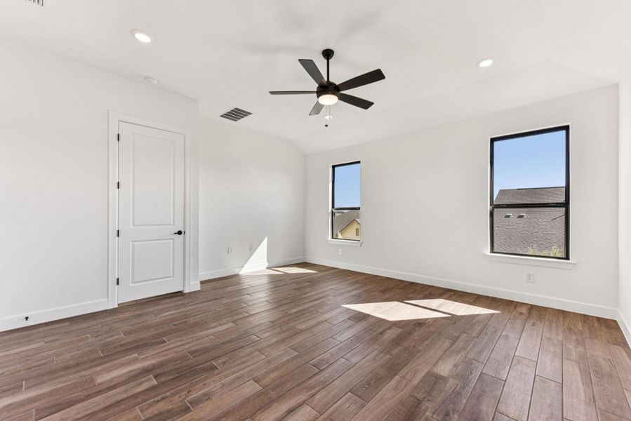 Spare room featuring healthy amount of natural light, recessed lighting, dark wood finished floors, and a ceiling fan