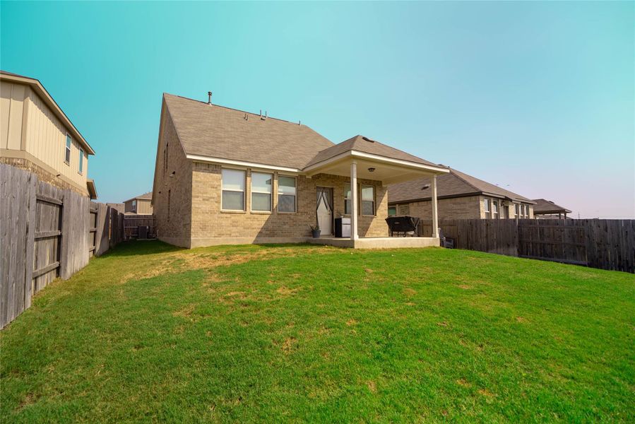 Back of house featuring a patio area, a fenced backyard, and brick siding Back of house featuring a patio area, a fenced backyard, and brick siding