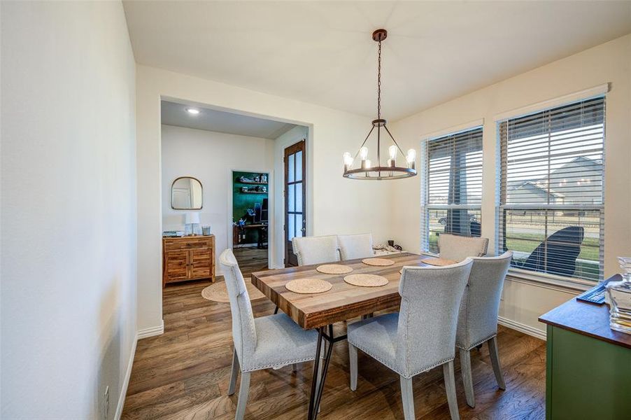 Dining space featuring wood finished floors and a chandelier