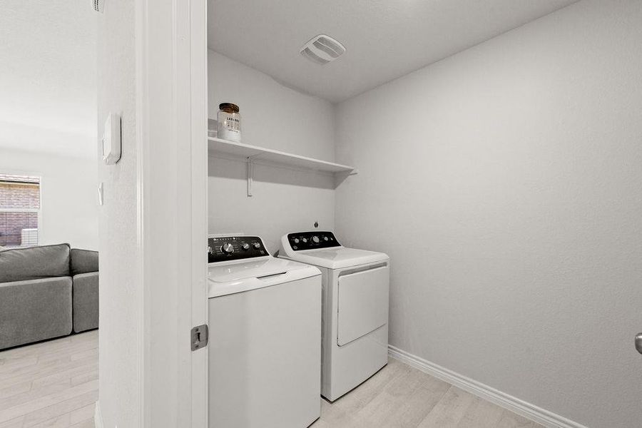 Washroom featuring light wood-style floors and separate washer and dryer