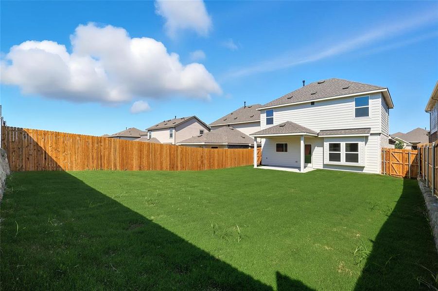 Back of property with a patio area, a fenced backyard, and a shingled roof