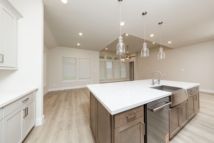 The kitchen island is a stunning centerpiece that anchors the space, while the layout provides a commanding view of the adjoining living areas and beyond. It features a seamless white quartz countertop that provides a vast workspace, complete with an integrated stainless steel apron-front farmhouse sink and a sleek, high-arc faucet. The kitchen island is a stunning centerpiece that anchors the space, while the layout provides a commanding view of the adjoining living areas and beyond. It features a seamless white quartz countertop that provides a vast workspace, complete with an integrated stainless steel apron-front farmhouse sink and a sleek, high-arc faucet.