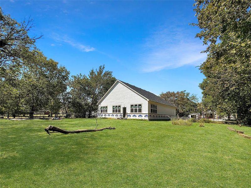 Back of property featuring a lawn Back of property featuring a lawn