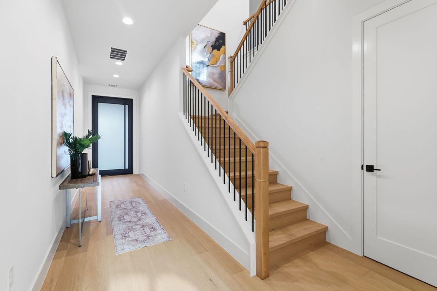 Entrance foyer with stairs, light wood finished floors, and recessed lighting