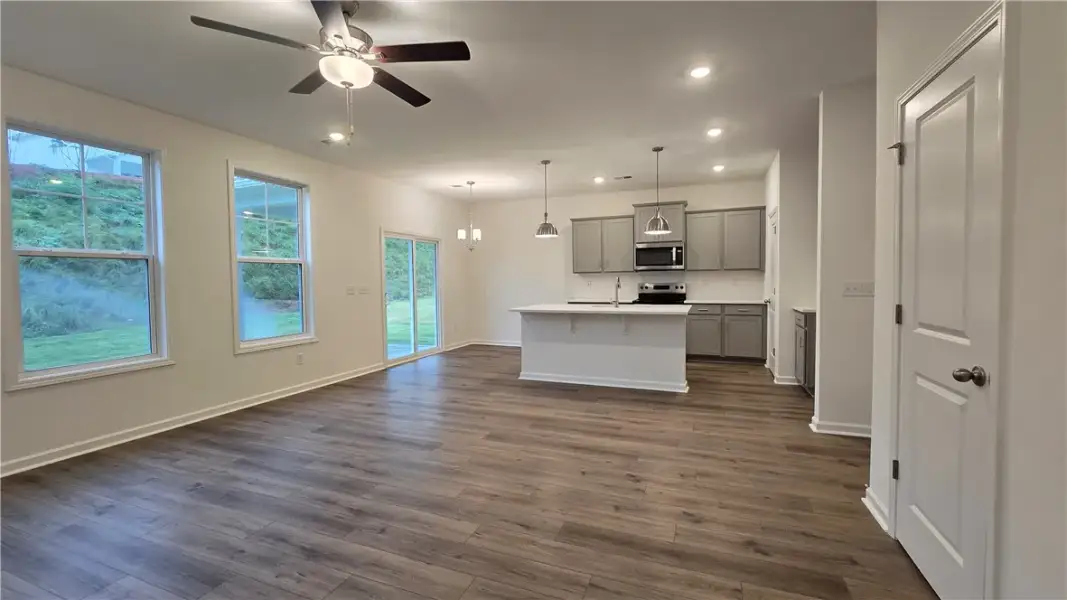 Rich wood-look flooring stretches across this open