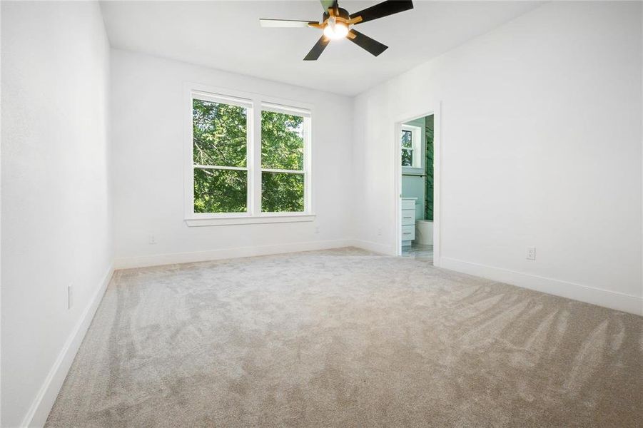 Empty room featuring ceiling fan and light carpet