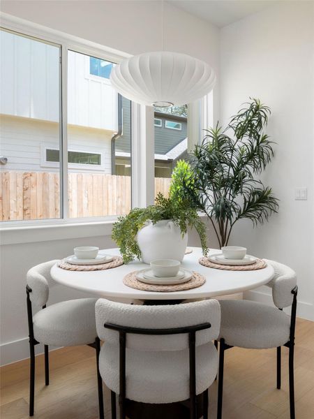 A well-lit breakfast nook offers ample seating and a view of the outdoors.