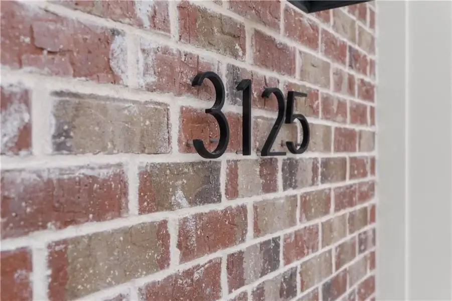 Brick exterior with contrasting white mortar and black house numbers