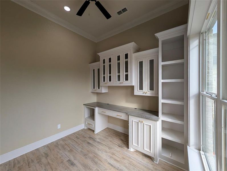 Unfurnished office with built in study area, crown molding, light wood-style flooring, a ceiling fan, and recessed lighting