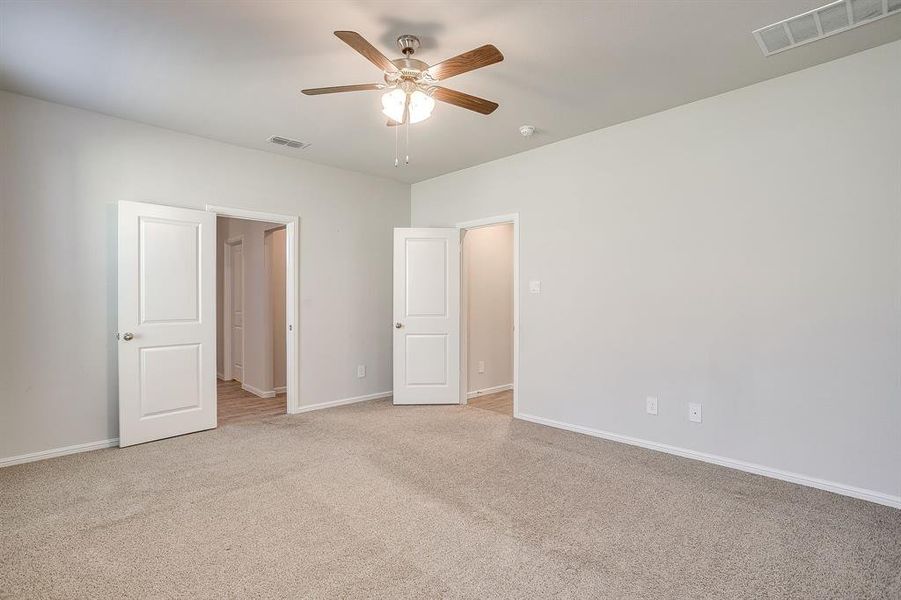 Unfurnished bedroom featuring light colored carpet and ceiling fan