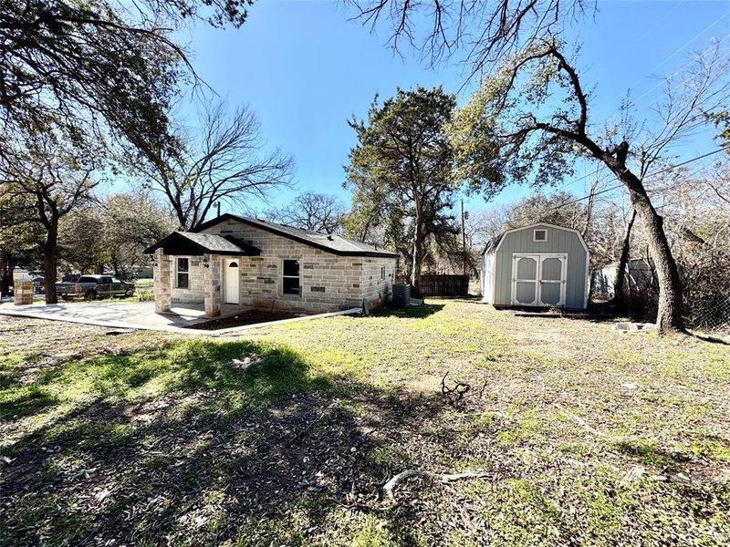 View of yard with a patio and a storage shed