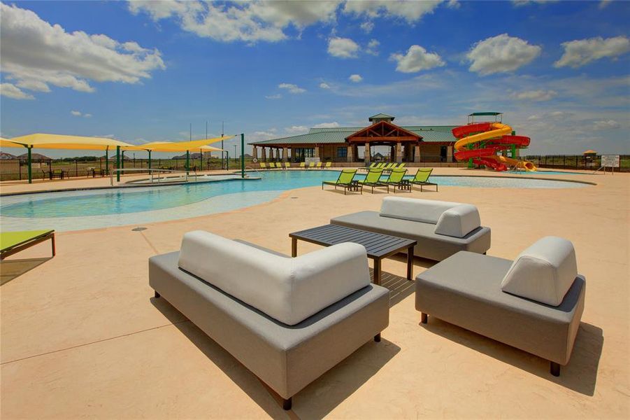 Expansive outdoor amenity area featuring a large swimming pool, multiple water slides, and dedicated lounge seating