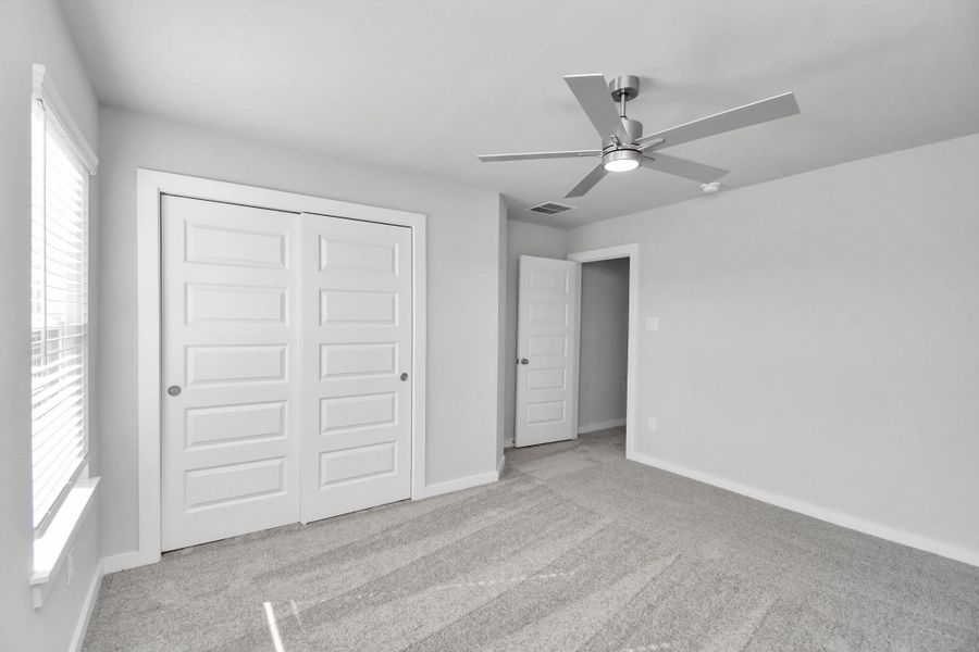 Generously sized secondary bedrooms featuring spacious closets, soft and inviting carpeting underfoot, large windows allowing plenty of natural light, and the added touch of privacy blinds for your personal retreat. Sample photo of completed home with similar floor plan. Actual colors and selections may vary.