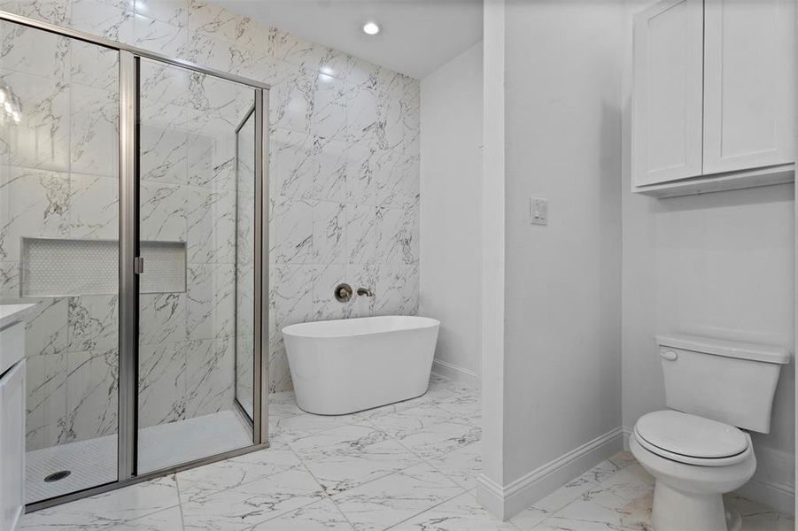Bathroom featuring marble finish flooring, a soaking tub, a marble finish shower, tile walls, and recessed lighting Bathroom featuring marble finish flooring, a soaking tub, a marble finish shower, tile walls, and recessed lighting