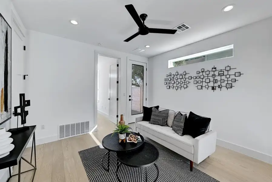 Living room featuring light wood-style flooring, a ceiling fan, recessed lighting, and baseboards